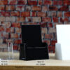 A sleek Clear, White of Black Pamphlet size Brochure holder placed on a countertop, creating a seamless and elegant look.