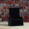 A sleek Clear, White of Black Pamphlet size Brochure holder placed on a countertop, creating a seamless and elegant look.