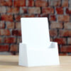 A sleek Clear, White of Black Pamphlet size Brochure holder placed on a countertop, creating a seamless and elegant look.